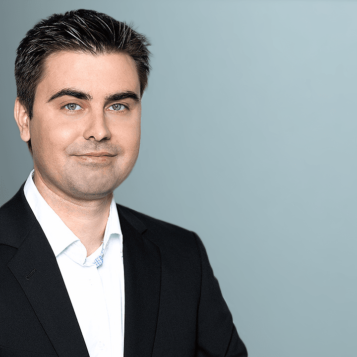 Porträt Pavel Mihaylov in dunklem Sakko und weißem Hemd vor blaugrauem Grund